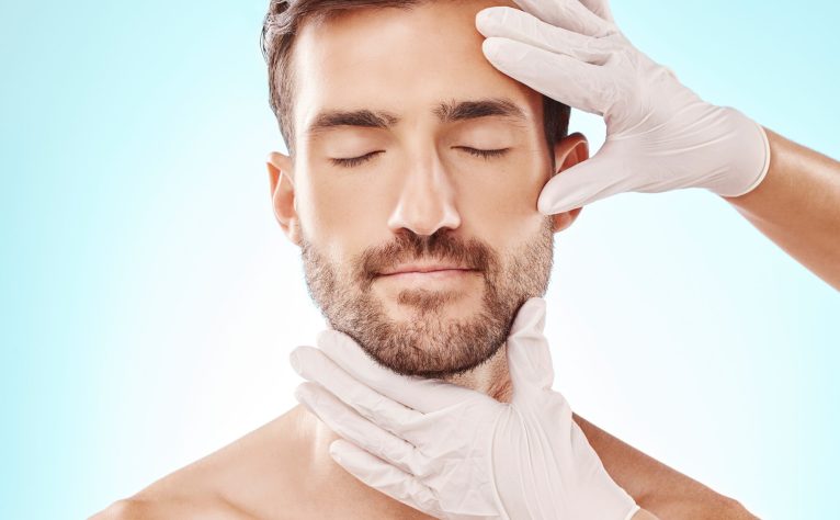 Man, face and facial care, hands and cosmetic service with beauty, healthy skin and glow on blue ba.